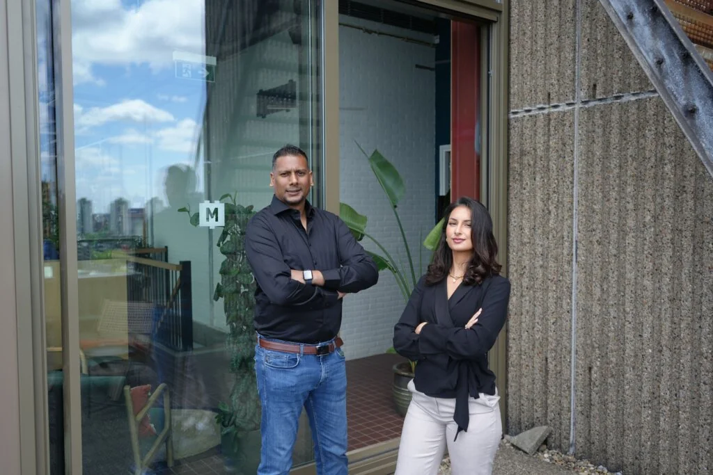 Twee collega’s van 1UP Talent voor de ingang van het kantoor