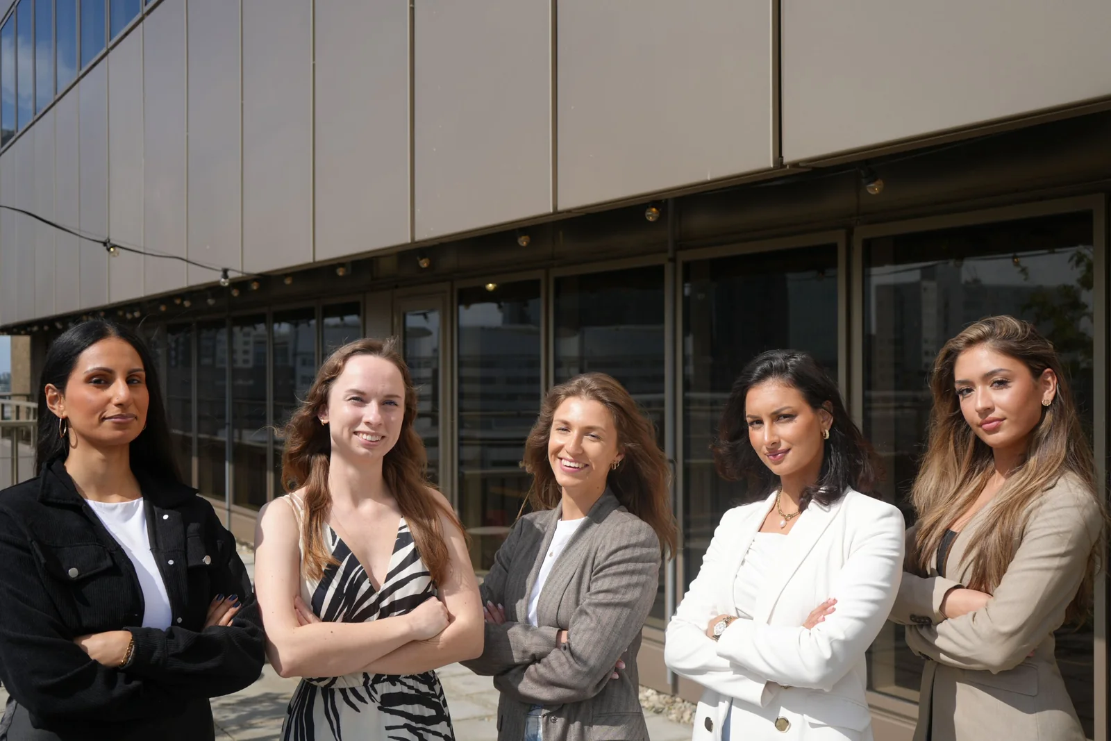 Vijf consultants van 1UP Talent staan met de armen over elkaar op een dakterras